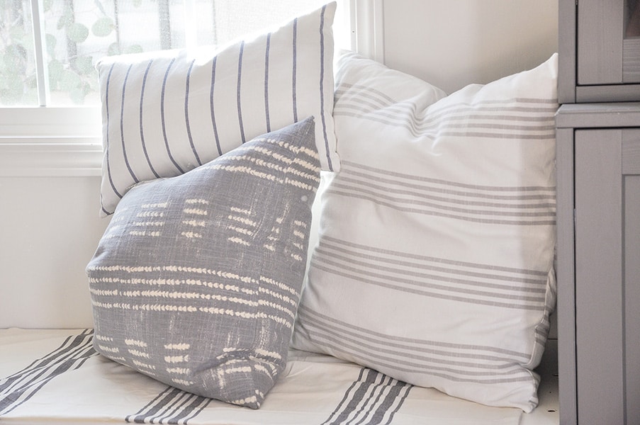 decorative throw pillows in stripe fabric, on window seat, ikea dish towel, tablecloth, pottery barn shobori dot napkin